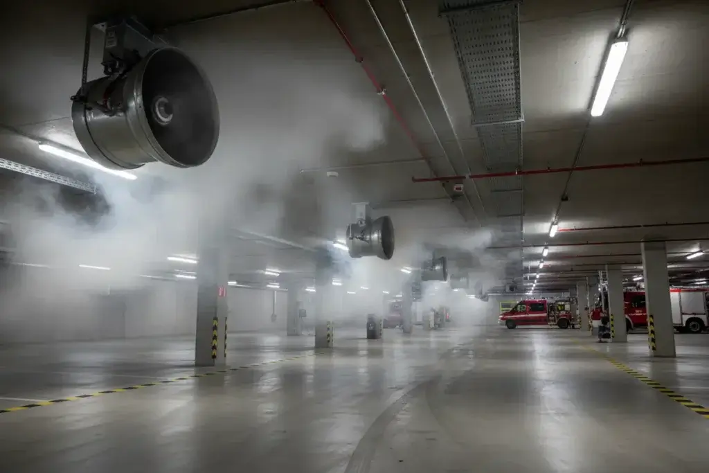 Testy mechanicznego systemu oddymiania w przestronnym garażu podziemnym.
